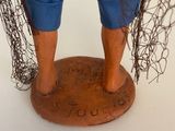 a figurine of a man with a fishing net on his feet