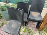 three black wicker chairs sitting next to each other on a brick patio