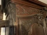 a wooden bed with a carved headboard on top of it