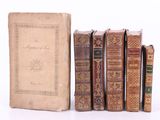 plusieurs vieux livres posés les uns sur les autres sur une surface blanche