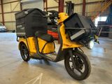 un scooter jaune avec un sac noir à l'arrière
