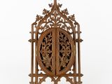 a carved wooden book stand with a cross on top of it