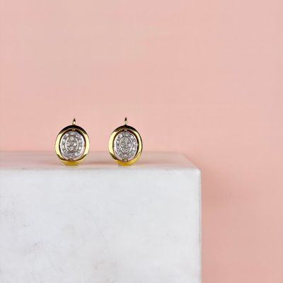 a pair of gold and white druzy stud earrings on a marble block