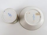 two white plates with blue designs on them on a white surface