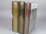 three books are stacked on top of each other on a white surface
