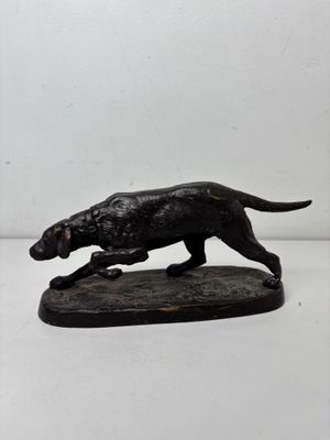 statue of a dog running on a wooden base on a white background