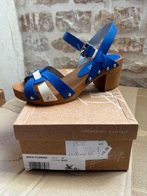 a close up of a pair of blue and white sandals on a cardboard box