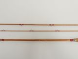 three wooden fishing rods are lined up against a white wall