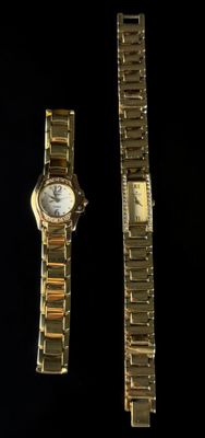 two watches sitting next to each other on a black surface