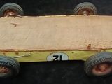 a wooden toy car with wheels and a number 21 on it