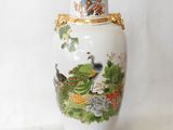a white vase with a painting on it sitting on a table