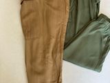 un pantalon posé sur un lit, à côté d'un oreiller
