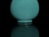 a blue vase with a red lid sitting on a black surface