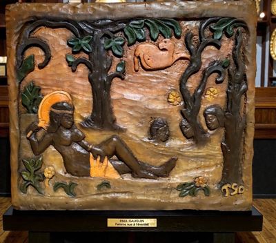 une sculpture représentant une femme assise sous un arbre