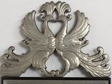 a metal plaque with a bird on it on the wall