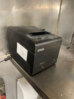 a black printer sitting on a metal counter in a kitchen