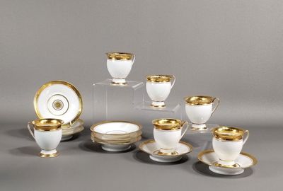 un ensemble de tasses à café et de soucoupes blanches et dorées