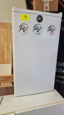 a white refrigerator with stickers on it in a room
