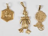 trois pendentifs en or représentant un garçon et une fille sur fond blanc