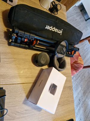 une table sur laquelle se trouvent un ordinateur portable, un appareil photo et d'autres appareils électroniques