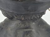 a close up of a metal vase with writing on it