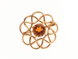un gros plan d'une bague en or ornée d'une pierre orange au centre