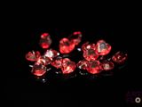 a close up of a bunch of red diamonds on a black surface