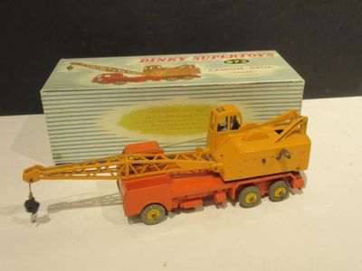 un camion jouet équipé d'une grue, à côté d'une boîte