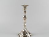 a silver plated candle holder sitting on top of a table