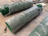 three rolls of green tarp sitting on the floor