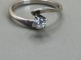 a silver ring with a diamond in it on a table