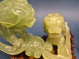 carved jade figurine of a woman and a dragon on a wood base