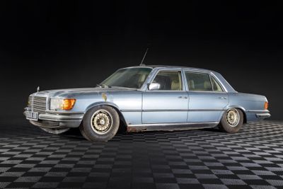 a blue car that is parked on a checkered floor