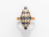 gros plan d'une bague en diamant et saphir sur une surface blanche
