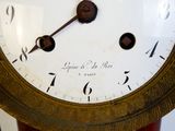 a clock that is sitting on a stand in the room