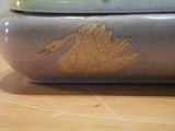 a ceramic container with a swan on it on a table