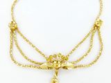 un collier plaqué or orné d'un pompon au bout d'une chaîne