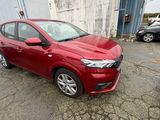une voiture rouge garée dans un parking à côté d'autres voitures