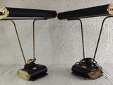 pair of black and gold desk lamps sitting on top of a white table