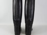 the back of a pair of black leather boots on a white surface