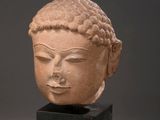 a close up of a statue of a head on a stand