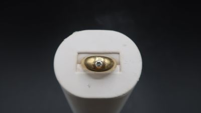 a close up of a white light bulb with a gold button