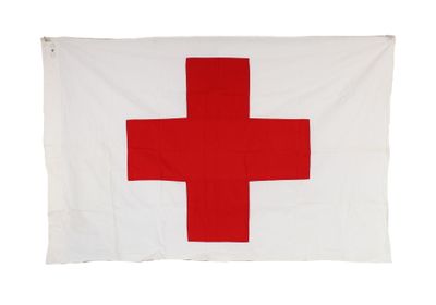 a red cross flag hanging on a white wall