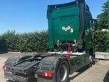a green dump truck that is parked in a lot