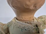 a close up of a doll with a dress on