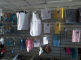 many baby clothes hanging on a wall in a store