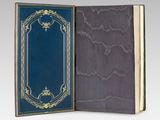 an open book with a blue cover and gold trim