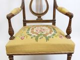 une vieille chaise avec une assise rembourrée jaune et un coussin à motifs floraux