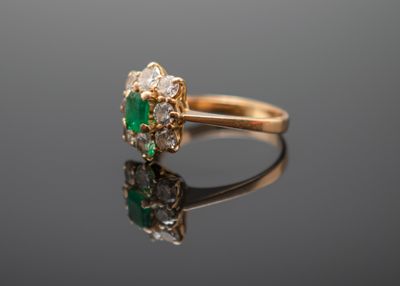 un gros plan d'une bague en or sertie d'une pierre verte et blanche