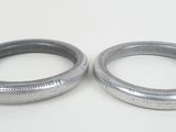 pair of stainless steel rings on a white surface